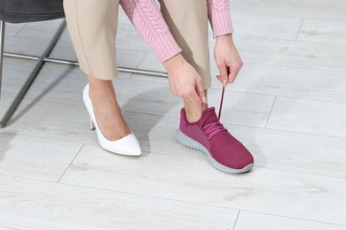 Photo of Woman changing shoes on chair at home, closeup. Space for text