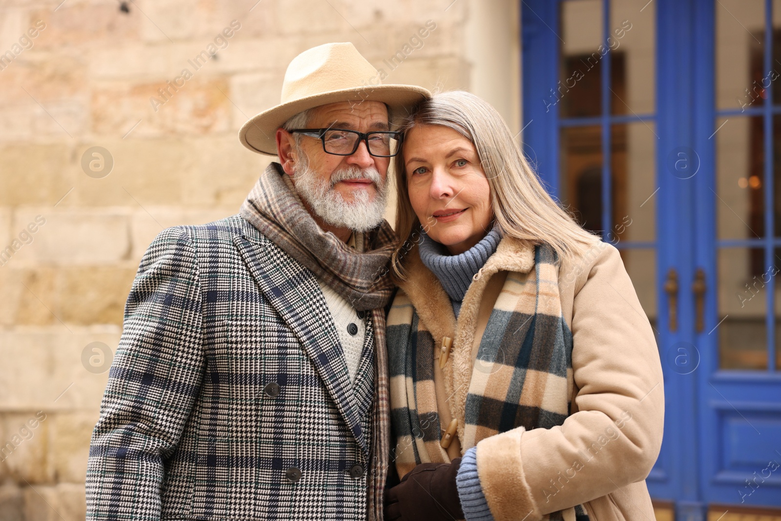 Photo of Family portrait of happy elderly couple on city street