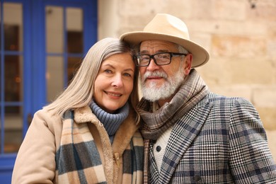 Photo of Family portrait of happy elderly couple on city street