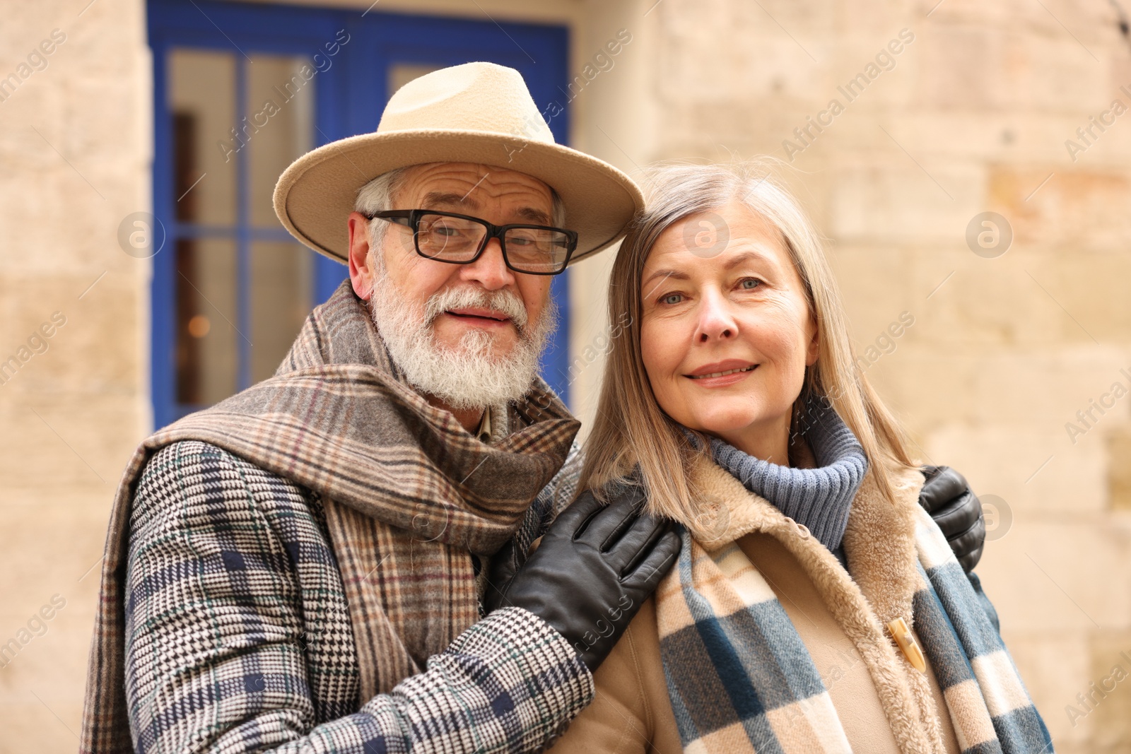 Photo of Family portrait of happy elderly couple on city street