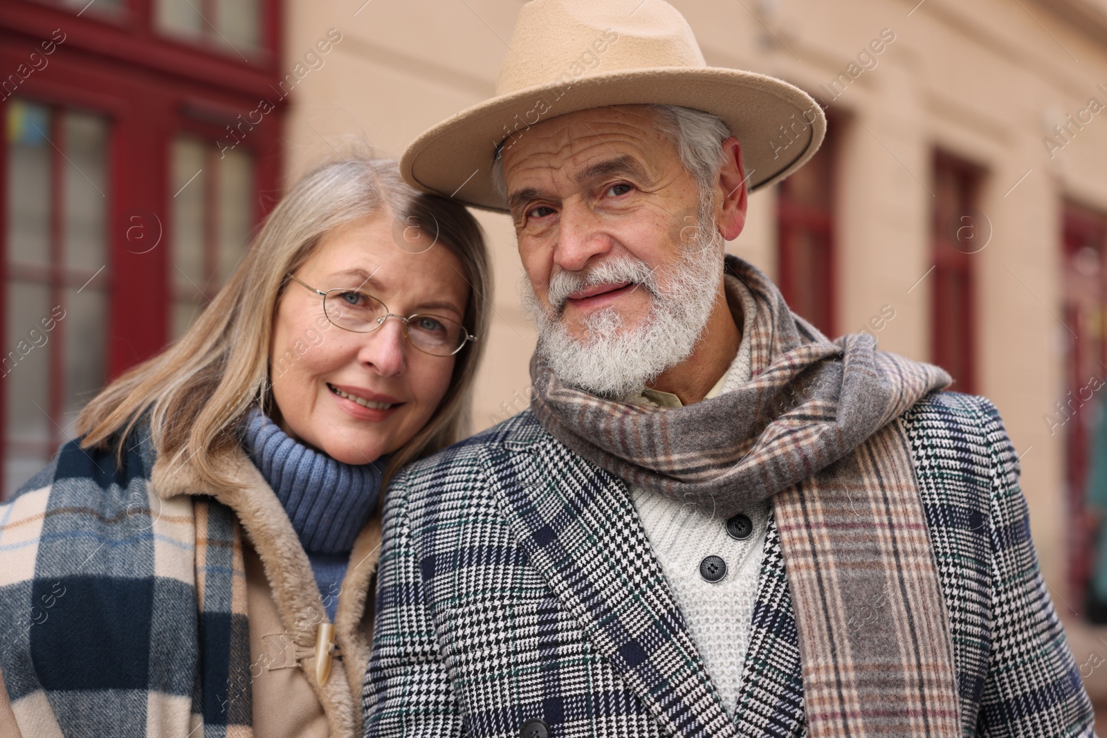 Photo of Family portrait of happy elderly couple on city street