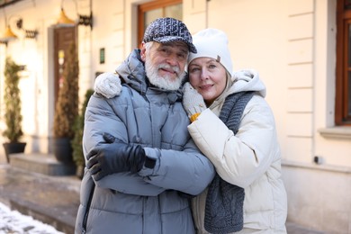 Photo of Family portrait of happy elderly couple on city street