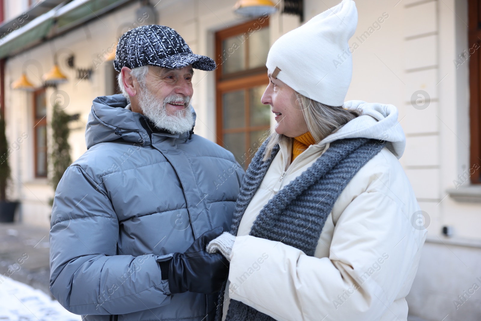 Photo of Happy elderly couple holding hands on city street