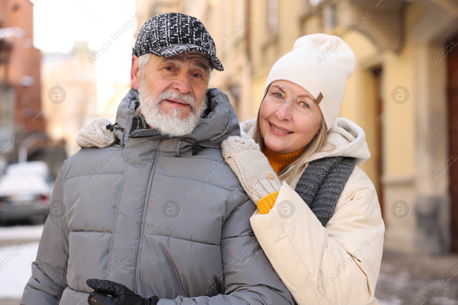 Photo of Family portrait of happy elderly couple on city street