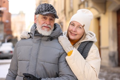 Photo of Family portrait of happy elderly couple on city street