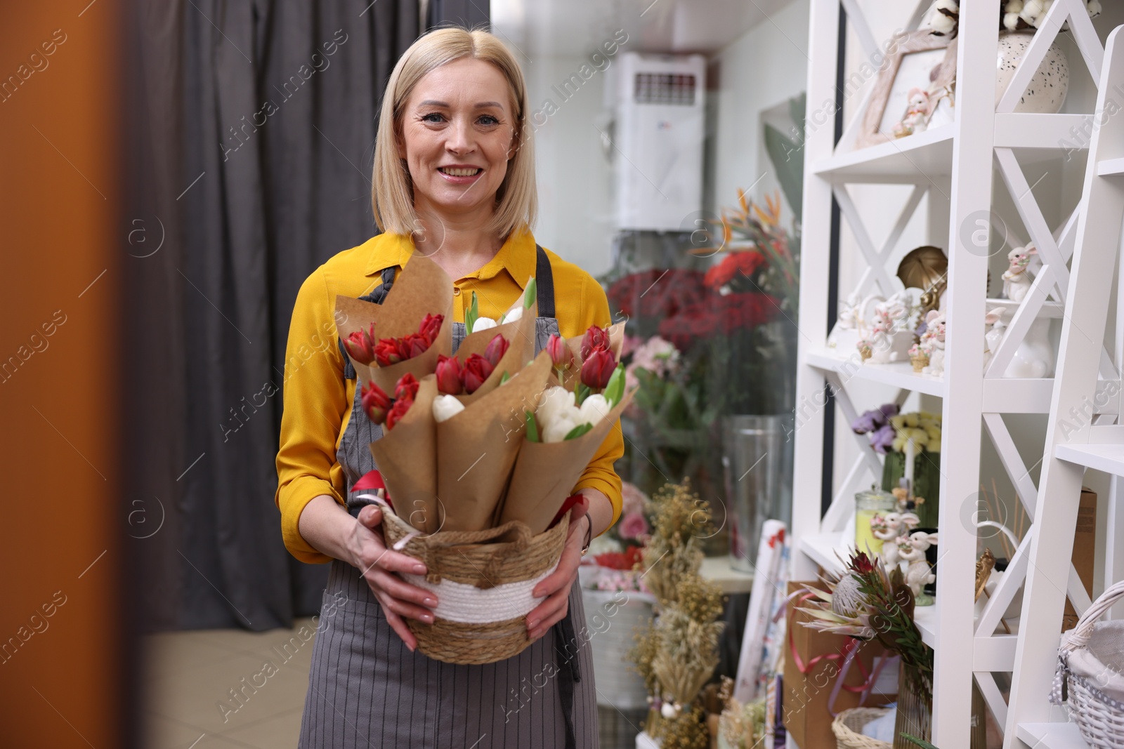 Photo of Business owner with beautiful tulips in her flower shop