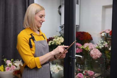 Photo of Business owner with tablet in her flower shop