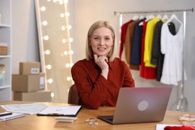 Photo of Business owner at table with laptop in her tailor shop