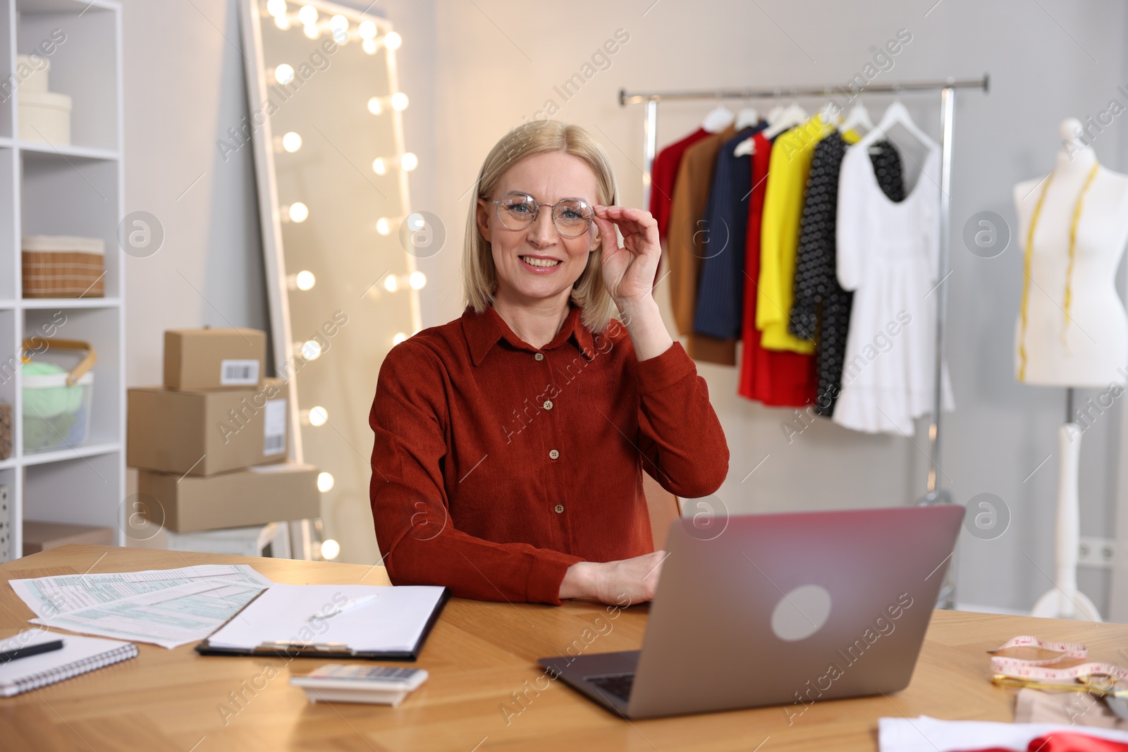 Photo of Business owner at table with laptop in her tailor shop