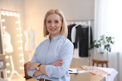 Photo of Business owner with crossed arms in her tailor shop, space for text