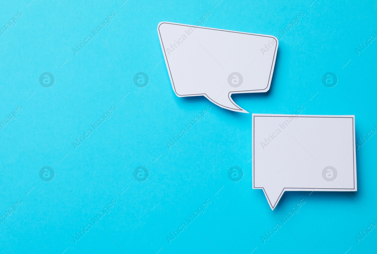 Photo of Blank speech bubbles on light blue background, top view. Space for text