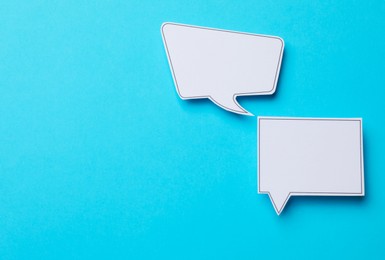 Photo of Blank speech bubbles on light blue background, top view. Space for text