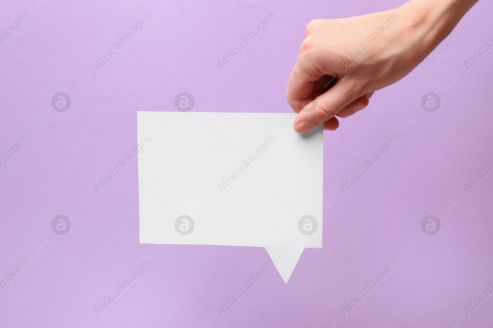 Photo of Woman holding blank speech bubble on lilac background, closeup. Space for text