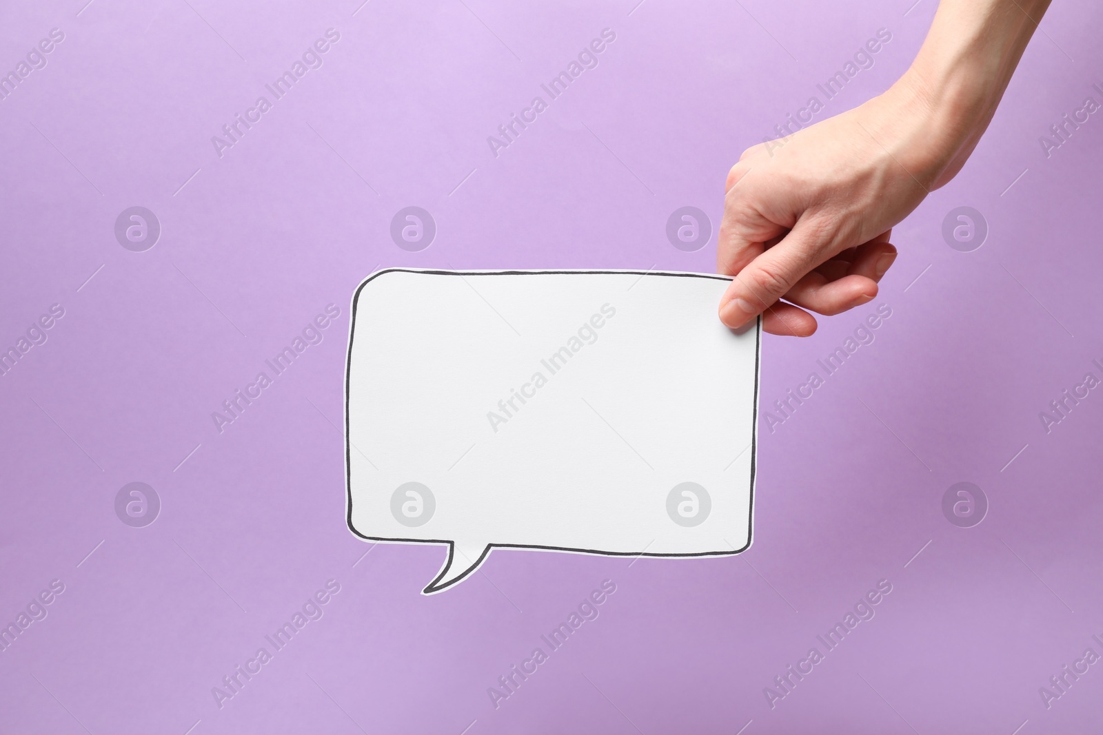 Photo of Woman holding blank speech bubble on lilac background, closeup. Space for text