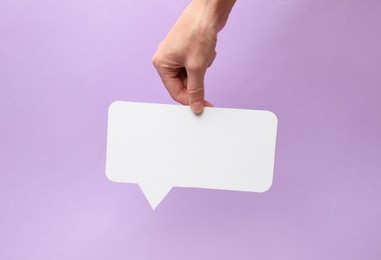 Photo of Woman holding blank speech bubble on lilac background, closeup. Space for text