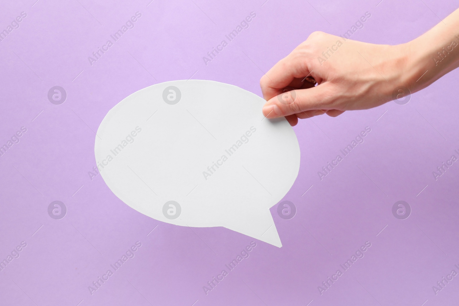 Photo of Woman holding blank speech bubble on lilac background, closeup. Space for text