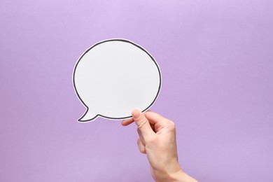 Photo of Woman holding blank speech bubble on lilac background, closeup. Space for text