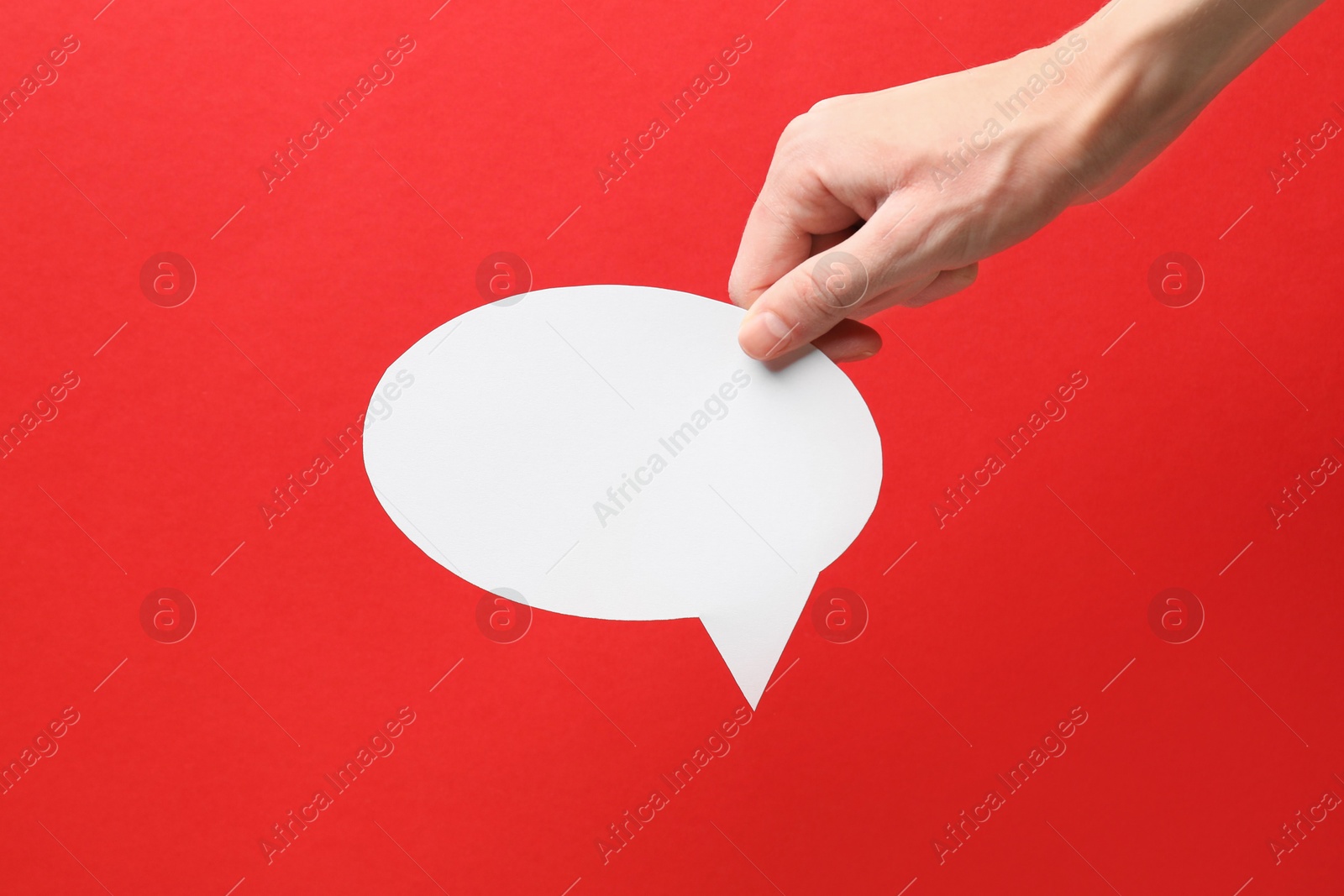 Photo of Woman holding blank speech bubble on red background, closeup. Space for text