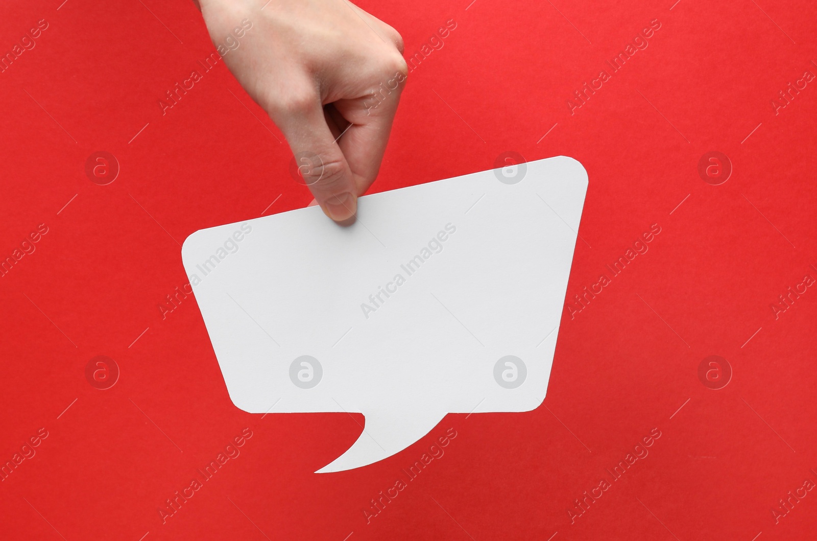 Photo of Woman holding blank speech bubble on red background, closeup. Space for text