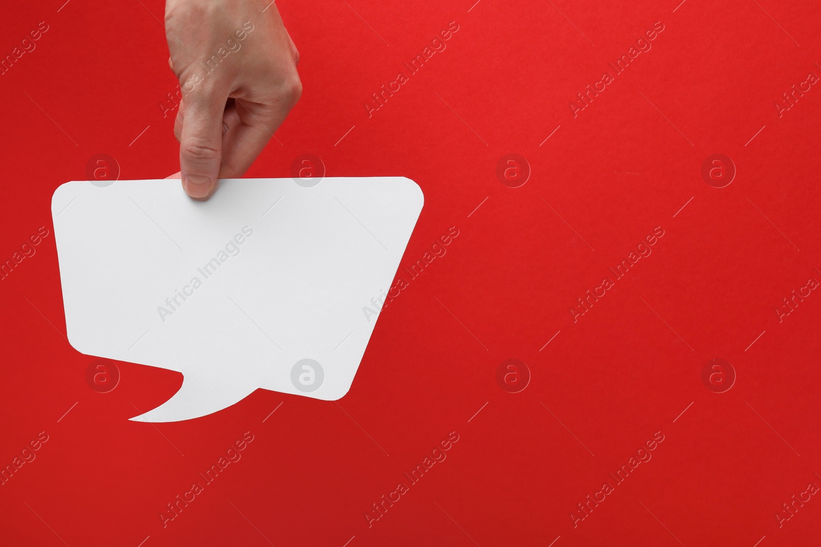 Photo of Woman holding blank speech bubble on red background, closeup. Space for text