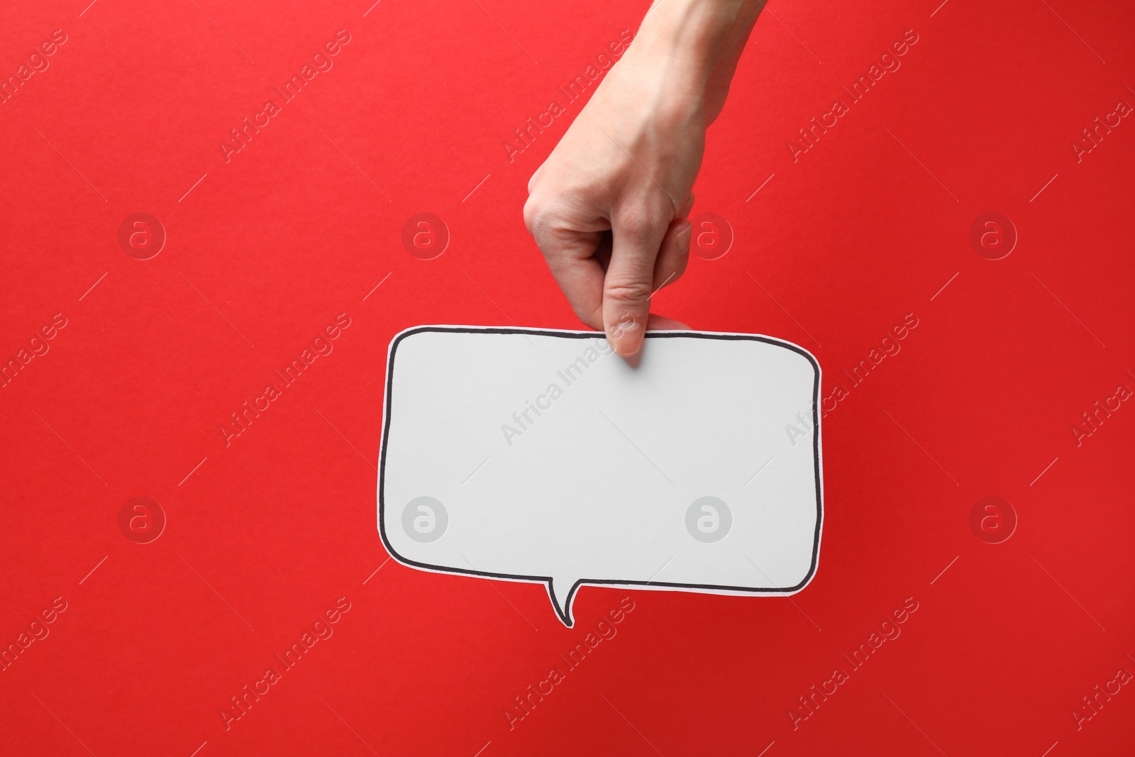 Photo of Woman holding blank speech bubble on red background, closeup. Space for text