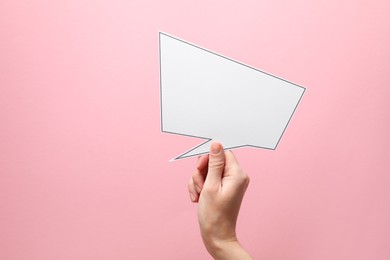 Photo of Woman holding blank speech bubble on light pink background, closeup. Space for text