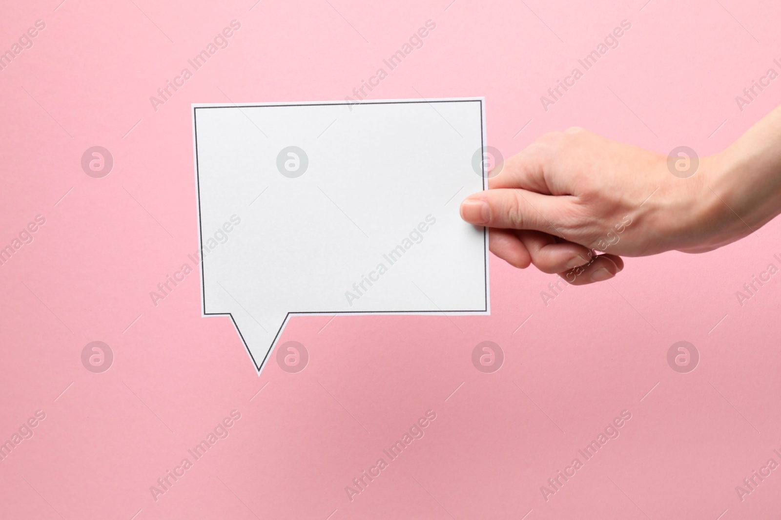 Photo of Woman holding blank speech bubble on light pink background, closeup. Space for text