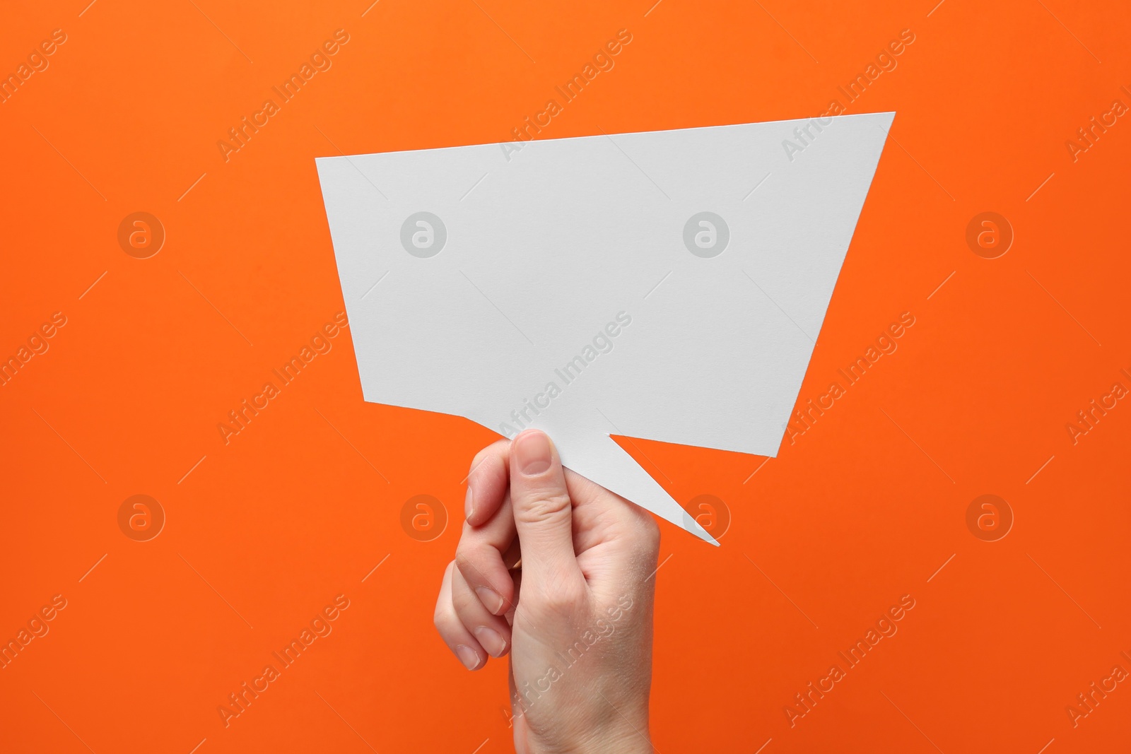 Photo of Woman holding blank speech bubble on orange background, closeup. Space for text