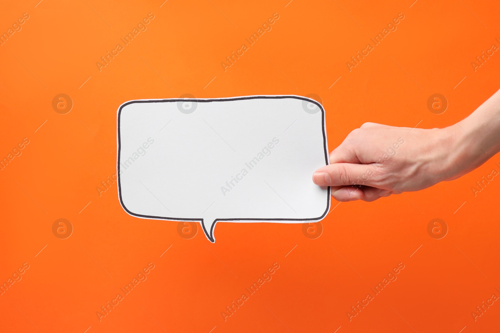 Photo of Woman holding blank speech bubble on orange background, closeup. Space for text