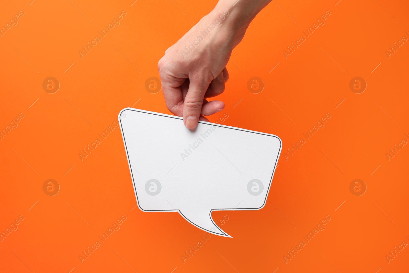 Photo of Woman holding blank speech bubble on orange background, closeup. Space for text