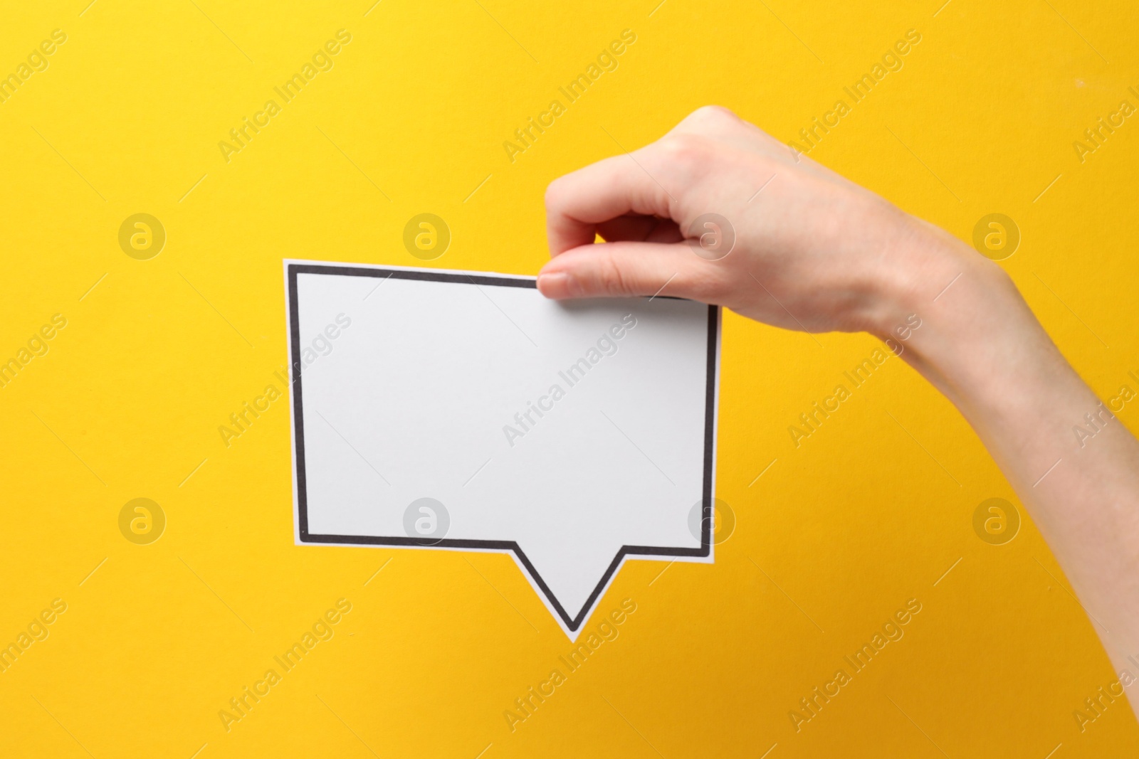 Photo of Woman holding blank speech bubble on yellow background, closeup. Space for text