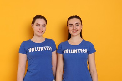 Photo of Portrait of smiling volunteers on orange background