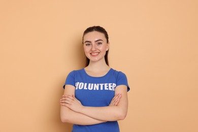 Photo of Portrait of smiling volunteer with crossed arms on beige background