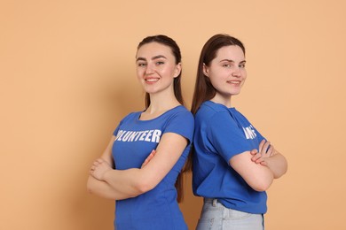 Photo of Portrait of smiling volunteers with crossed arms on beige background