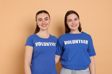 Photo of Portrait of smiling volunteers on beige background