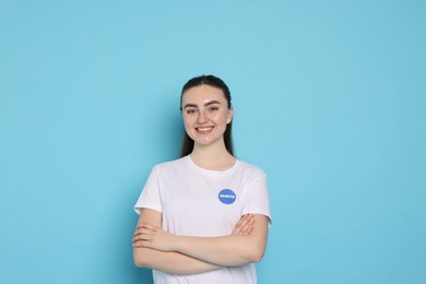 Photo of Portrait of smiling volunteer with crossed arms on light blue background