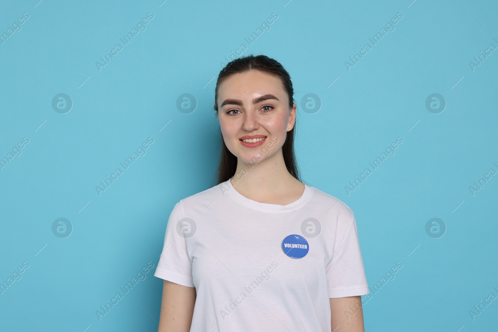 Photo of Portrait of smiling volunteer on light blue background