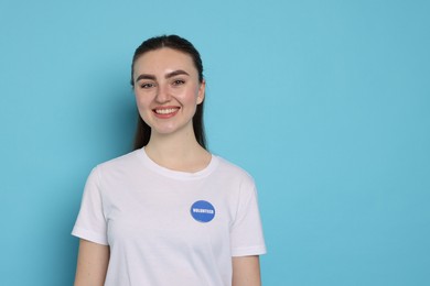 Photo of Portrait of smiling volunteer on light blue background. Space for text