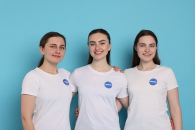 Photo of Team of smiling volunteers on light blue background