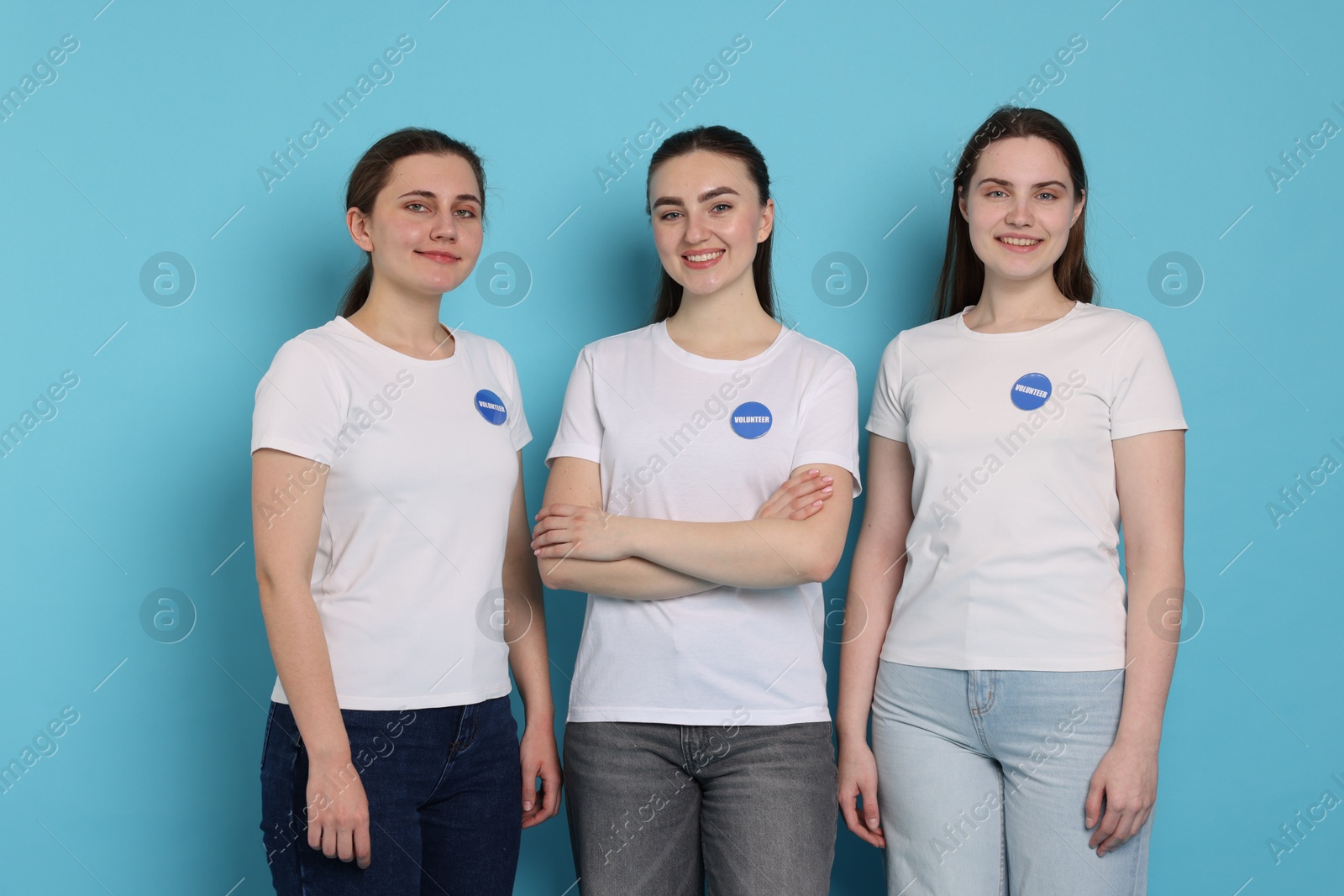 Photo of Team of smiling volunteers on light blue background