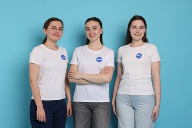 Photo of Team of smiling volunteers on light blue background