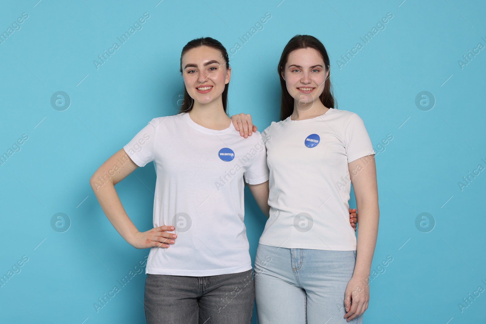 Photo of Portrait of smiling volunteers on light blue background