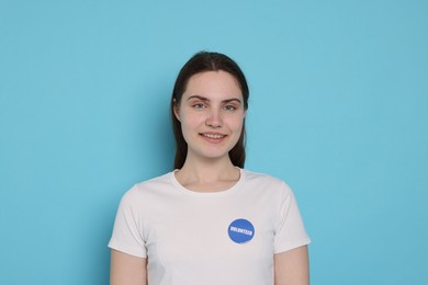 Photo of Portrait of smiling volunteer on light blue background