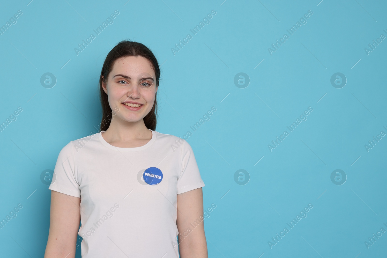 Photo of Portrait of smiling volunteer on light blue background. Space for text