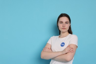 Photo of Portrait of volunteer with crossed arms on light blue background. Space for text