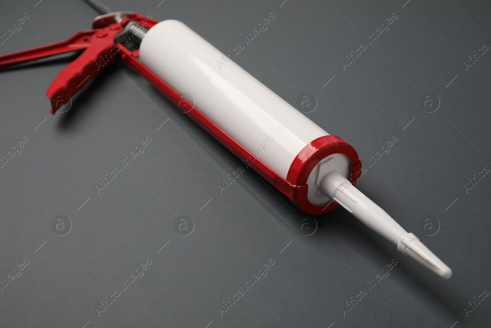 Photo of One glue gun on gray background, closeup