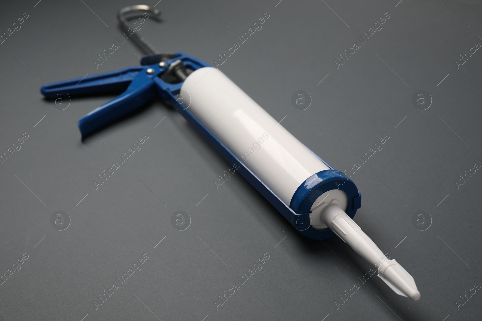 Photo of One glue gun on gray background, closeup