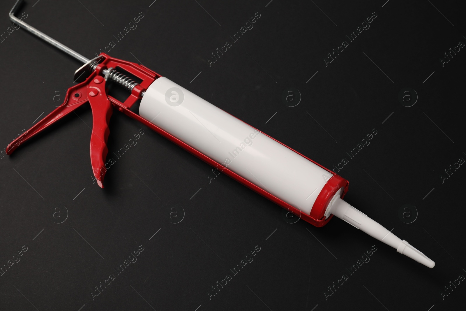 Photo of One glue gun on black background, top view