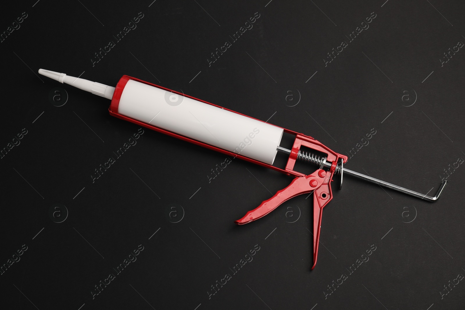 Photo of One glue gun on black background, top view