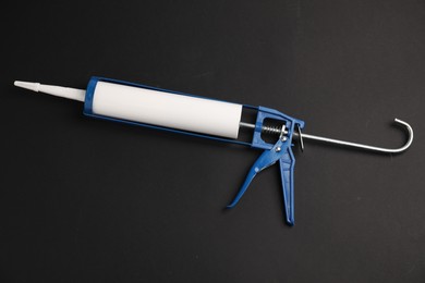 One glue gun on black background, top view